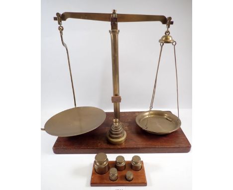 A brass set of W A Webb pharmacists scales on oak base with set of brass weights 