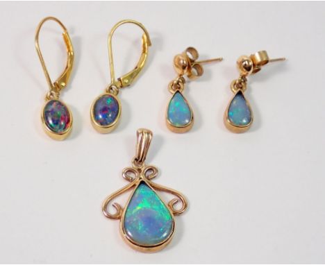 A 9 carat gold opal pendant with scrollwork shoulders, 2.5cm drop, 2g plus two pairs of 9 carat gold opal earrings (one pair 