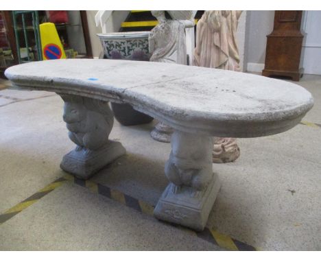 A composition stone bench with a curved seat on squirrel pedestals A/F 