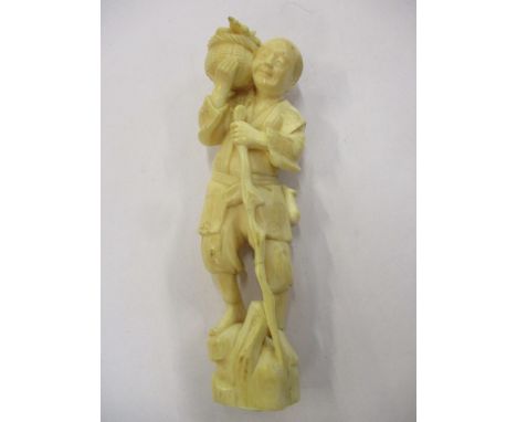 A Japanese carved ivory figure of a gent with a walking stick carrying a basket of fruit on his shoulder 6"h 