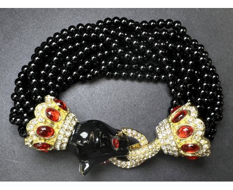 A multi strand black glass bead bracelet, the clasp is a jaguar head with red glass eyes with gilt, rhinestone and red stone 