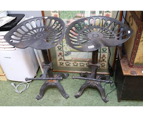 Pair of Cast Iron Tractor seat Stools with twisted footrest and scroll feet 