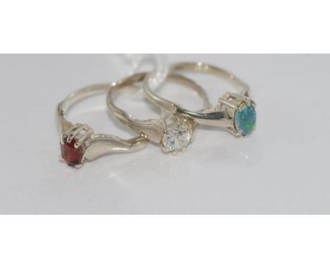 Three silver stone set rings including opal , garnet and clear stone, sizes: K-L-M/5-6