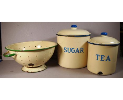 Two vintage enamel canisters together with an enamel colander