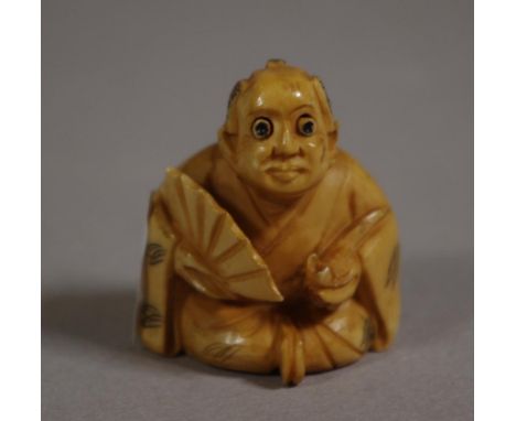 Antique Japanese ivory netsuke depicting a man holding a fan, signed to base, 4cm high approx. NB These may not be exported w