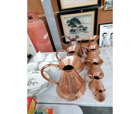 A SET OF EIGHT VINTAGE COPPER HAYSTACK JUGS 