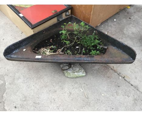 A CAST IRON CORNER TROUGH WITH TIE RING 