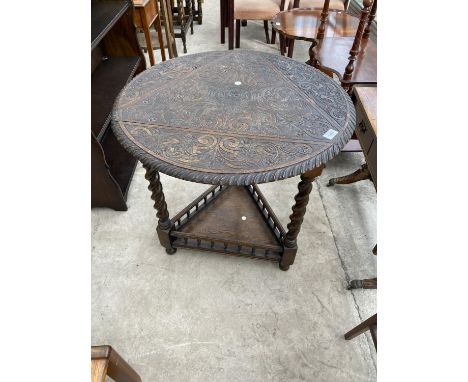 A TRIANGULAR OAK DROP LEAF OCCASIONAL TABLE ON BARLEY TWIST SUPPORTS WITH HEAVILY CARVED TOP, PIE CRUST EDGE AND GALLERIED LO