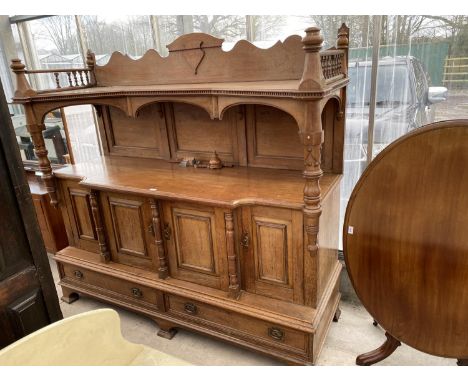 A LARGE OAK SIDEBOARD WITH FOUR DOORS, TWO DRAWERS AND UPPER GALLERIED SHELF 