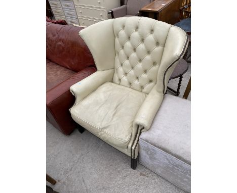 A STUDDED CREAM LEATHER WING AND BUTTON BACK ARMCHAIR 
