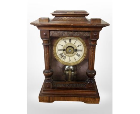 A carved and stained pine 8-day mantel clock, height 35cm.