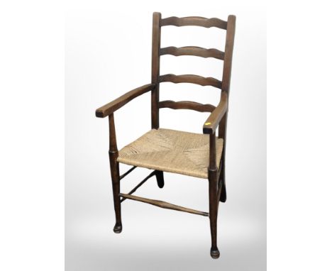 An oak and rattan ladder-back farmhouse armchair, width 54cm.