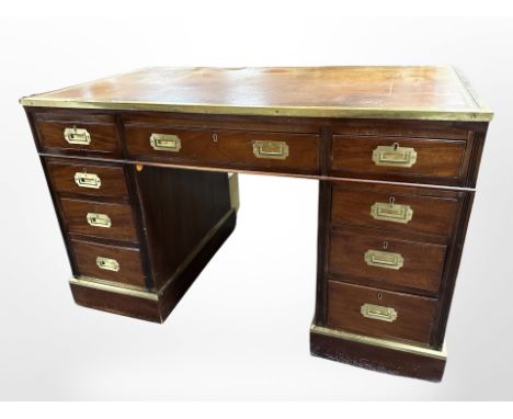 A late 19th-century continental campaign-style mahogany and brass-mounted twin-pedestal desk with tooled leather inset panel,