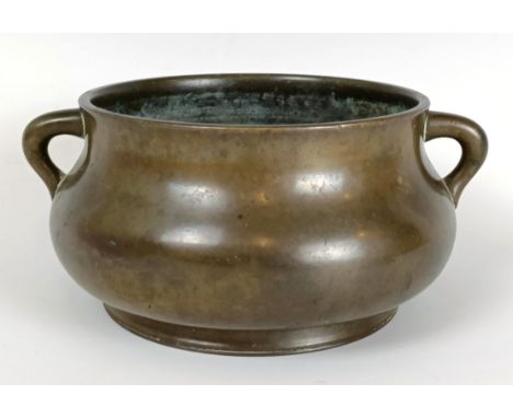 A Chinese bronze censer, of compressed circular form and with twin handles, character mark to base, 19 cm wide1142g