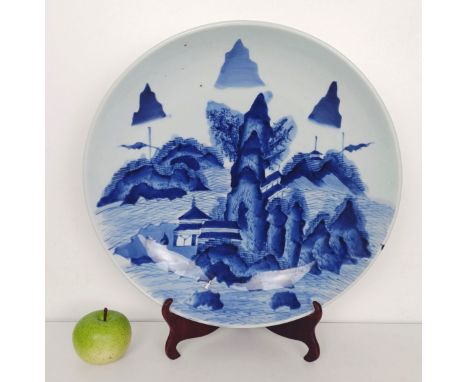 A Japanese blue and white dish, decorated a landscape, 41 cm diameter