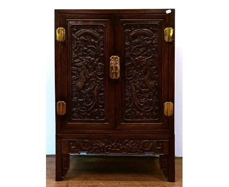 A Chinese hardwood cupboard, with two cupboard doors and a single drawer, carved dragons, 76 cm wide