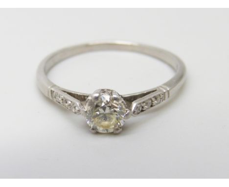 A white metal set diamond solitaire ring, approximately .50ct weight, with diamond shoulders, 2.2g, N