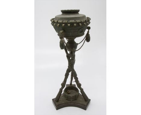An unusual oil lamp, the chimney a castellated design strung with decorative hand grenades, the tripod stand in the form of t