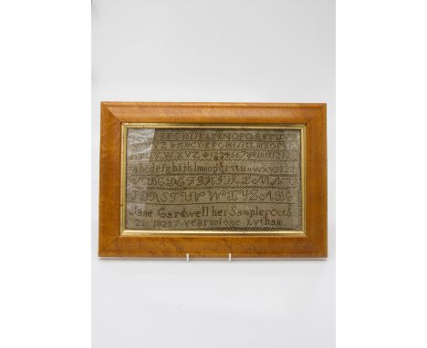 An early 19th century needlework alphabet sampler, worked by Jane Cardwell of Lytham aged 7, dated 1823, in bird's eye maple 