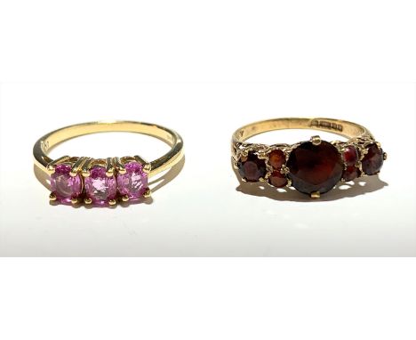 A ring set red stones and another set pink stones.