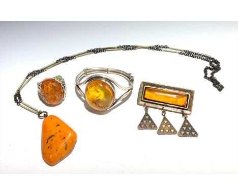 An amber set silver bracelet, an amber and silver ring, a necklace with a large amber drop and an amber brooch.