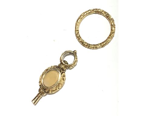 A gold watch key and a gold split ring.