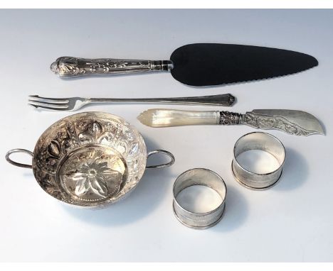 A Thomas Bradbury &amp; Sons Ltd repoussé decorated twin handled silver dish, a pair of engine turned silver napkin rings, a 