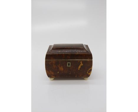 An early 19th century tortoiseshell tea caddy on four bun feet, with fitted two division interior. (Dimensions: Height 10.5cm