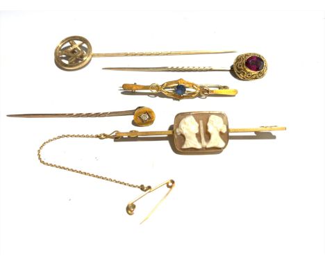 Three gold stick pins, a gold bar brooch set with a cameo and one other bar brooch.