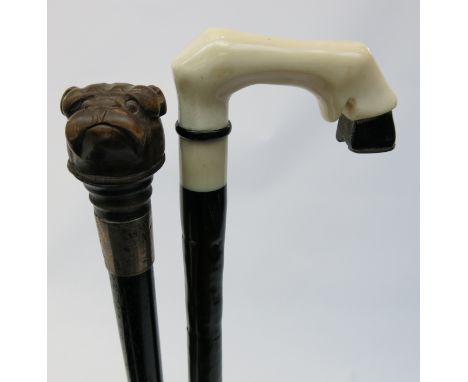 A Victorian ebonised walking cane, the carved wood knop in the form of a dog, together with another walking stick, the handle