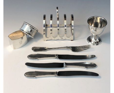 A silver toast rack, a silver egg cup, two silver napkin rings, a Victorian silver fork, 6oz, together with three silver hand