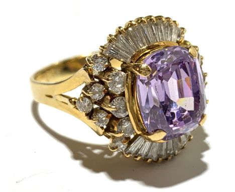 An 18ct gold costume ring set a central amethyst surrounded by pave set and single diamonds.