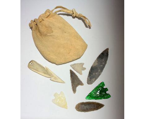 An opal arrow head, a green glass arrow head and five related pieces.