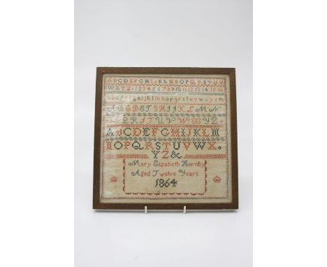 A 19th century needlework alphabet sampler, worked by Mary Elizabeth Hornby aged 12, dated 1864. (Dimensions: 26.5cm x 26.5cm