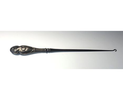 A large button hook with filled silver handle, embossed with cherubs.