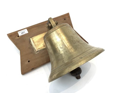 A brass bell, with iron clanger, brass bracket and shaped wooden backplate. (Dimensions: The bell height 17cm)(The bell heigh