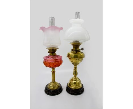 A late 19th/early 20th century brass oil lamp with cranberry reservoir and etched glass shade, on circular stepped base,toget