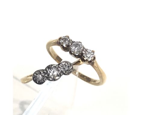 An 18ct gold three stone diamond ring and a second similar ring.