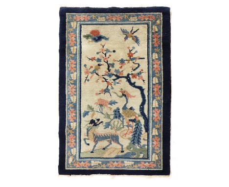 A Chinese rectangular carpet, depicting a peacock and a qilin standing below a blossoming tree, 136 x 73cm麒麟图地毯Condition repo