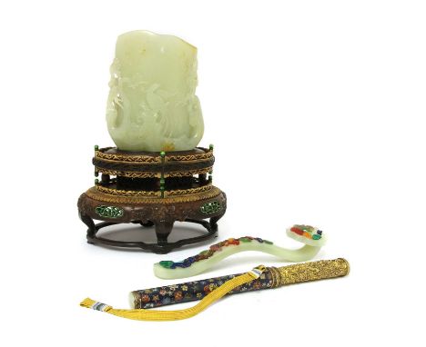A Chinese jade carving, with a pheasant standing on a rock, surrounded by pine, bamboo and prunus, 12.4cm high, wood stand, a