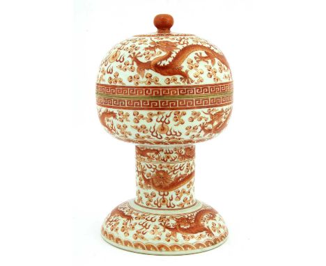 A Chinese iron-red dou and cover,the archaic stem bowl decorated with dragons chasing a flaming pearl amongst clouds, the dom