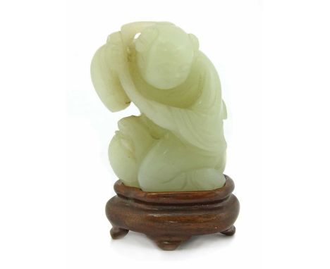 A Chinese jade carving,late Qing dynasty, of a boy carrying millet on his shoulder, riding on the back of a carp, the stone o