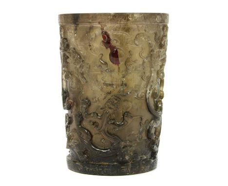 A Chinese smoky quartz brush pot,mid-Qing dynasty, of tapering cylindrical form, deeply carved with a group of chilong fighti