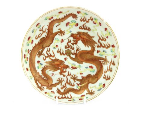 A Chinese famille rose plate,Xuantong (1909-1911), of circular form, painted with two dragons chasing a flaming pearl amongst