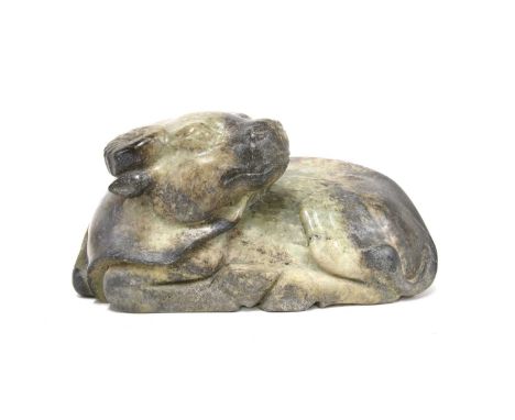 A Chinese jade carving, early 20th century, of a recumbent buffalo turning its head to the back, the greyish-celadon stone su