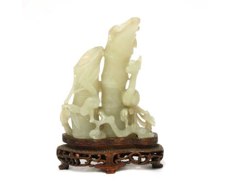 A Chinese jade carving,Qing dynasty (1644-1911), of a phoenix standing on lingzhi stems next to bamboo, 10cm high, wood stand