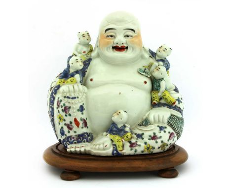 A Chinese famille rose Budai,20th century, his garment painted with florets with scroll borders, his right hand with a rosary