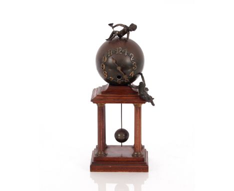 A mahogany and spelter mantel clock,&nbsp;in the form of a sphere with cherub surmounts raised on a four Corinthian column st