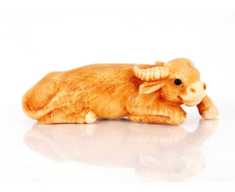 A Japanese carved ivory Netsuke,&nbsp;of a recumbent ox, signed with character marks&nbsp;