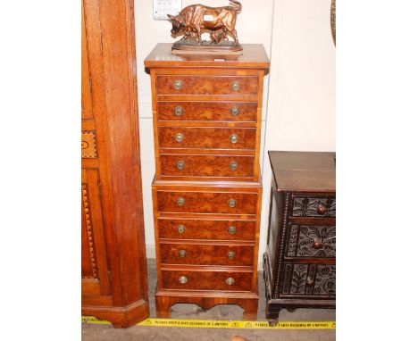 A reproduction yew wood miniature tall boy chest,&nbsp;fitted eight drawers raised on a shaped apron and bracket feet, 47cm w